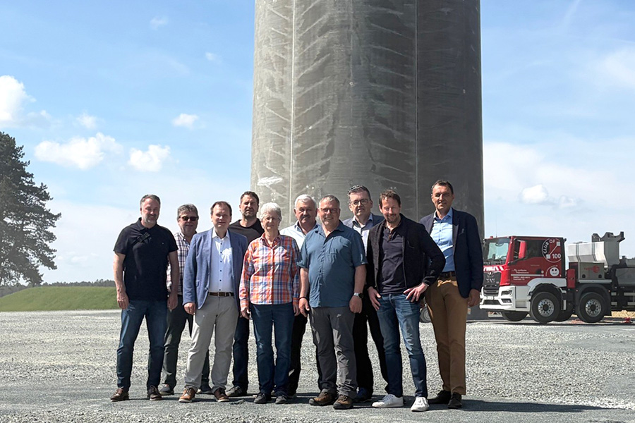 Gruppenbild vor einem der neuen Windräder mit Hybridturm